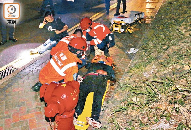 救護員在場拯救房車司機（右），男乘客則坐於行人路旁。