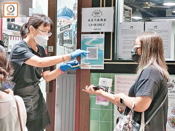 職員檢視食客「安心出行」及接種紀錄二維碼。