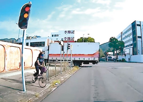 單車衝出馬路，交通燈已轉為黃燈。