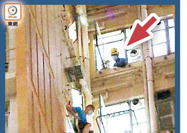 葵涌邨：消防員（箭嘴示）在樓上單位窗邊戒備。（余宏基攝）