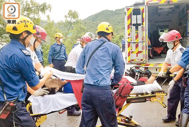 女事主被抬上救護車。