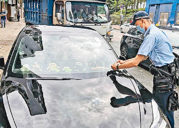 警方向違泊私家車發出罰款告票。