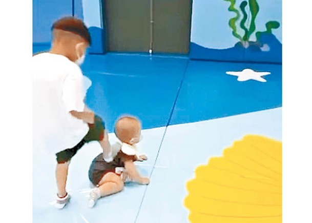 片段顯示涉事男童正在腳踏一名幼兒的背部。