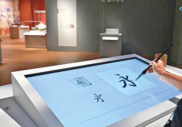 互動書法螢幕可讓訪客試寫，揣摩乾隆摹寫《蘭亭序》的神韻與技法。