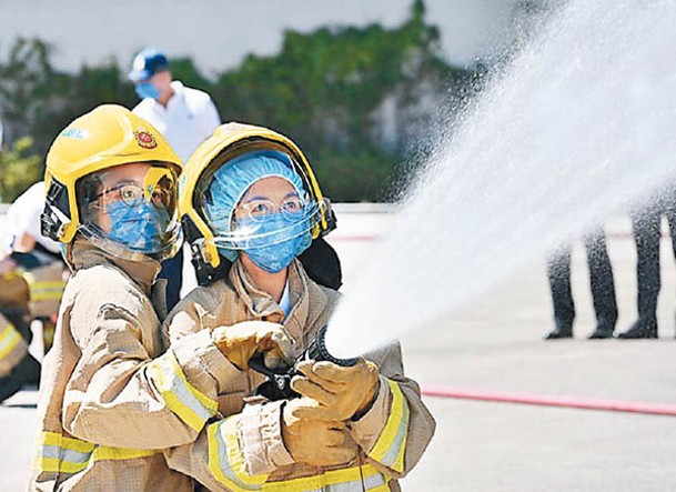 團員穿上滅火防護服，模擬於火場灌救。