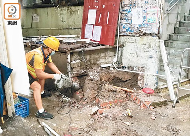 工人以電炮拆除石屎建築物。