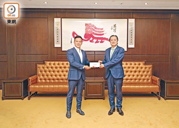 東方傳媒機構高層（左）致送支票予保良局主席陳正欣博士（右）。