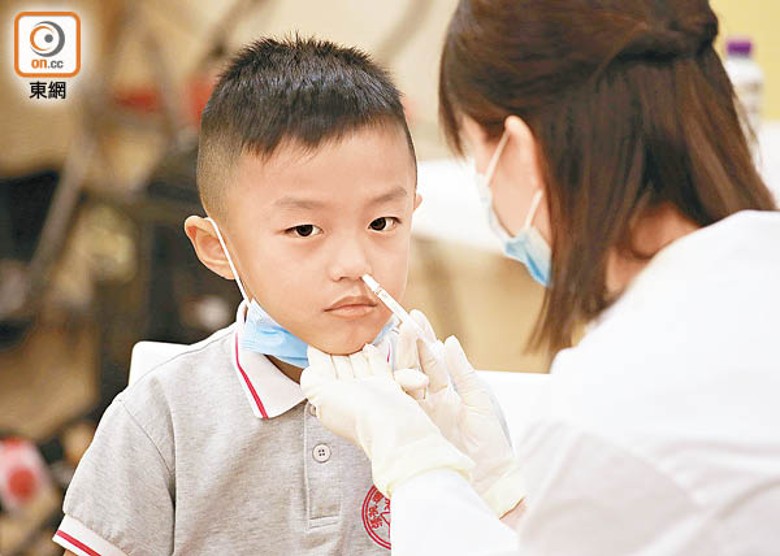 藥劑師即場示範為學童接種噴鼻式疫苗。（袁志豪攝）