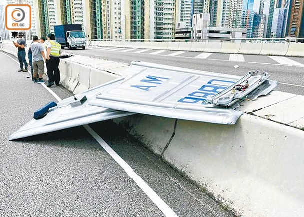 警車車頂一分為二，擱在路中石壆。