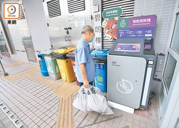 有長者嘗試了解廚餘機操作說明。（袁志豪攝）