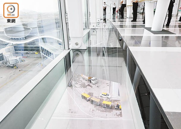 走廊部分地板以玻璃設置，旅客可透過腳下玻璃觀看飛機經過橋底。