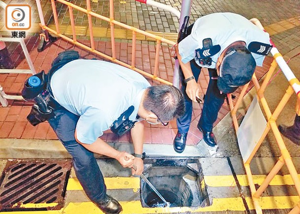 警員嘗試用工具檢回銀包。（楊日權攝）