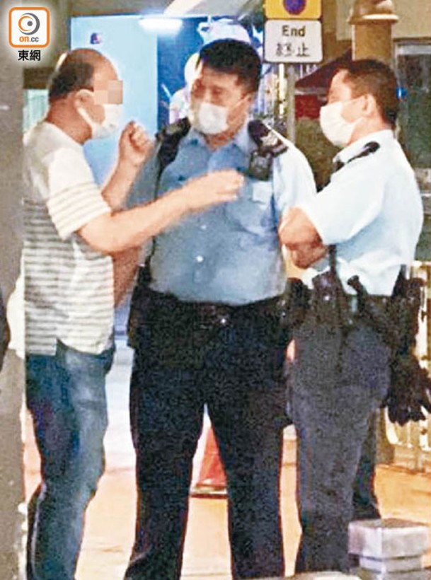 西灣河：涉事男乘客（左）要求警員出示委任證。