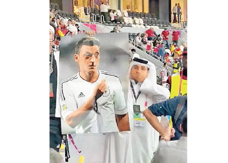 卡塔爾球迷高舉奧斯爾畫像，並且掩嘴，諷刺德國虛偽。