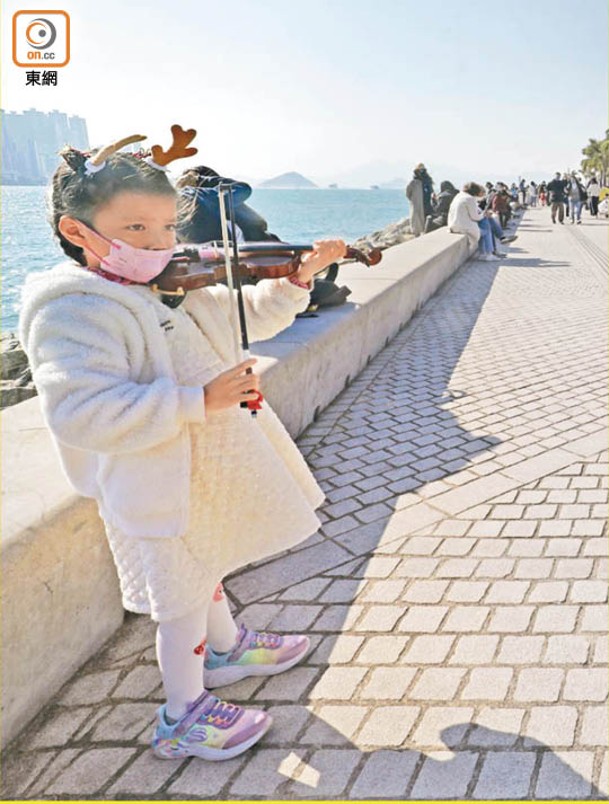 有小女孩以小提琴為悠閒的下午配樂。