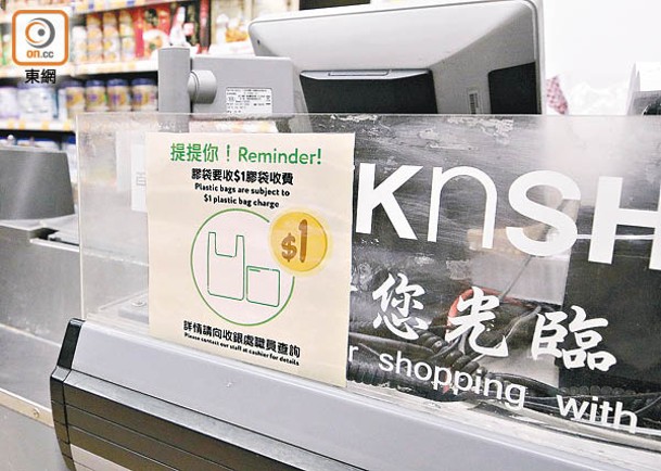 超市在櫃位處張貼膠袋徵費新措施的告示。