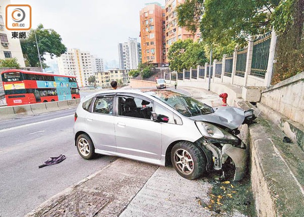 九龍塘：私家車撼石牆，車頭毀爛不堪。（張開裕攝）