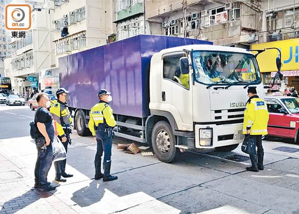 司機（左一）在場助查，車底遺下紙皮。（蘇偉明攝）