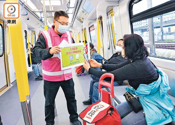 港鐵職員在列車上提醒過境往內地乘客填寫電子健康申報表。