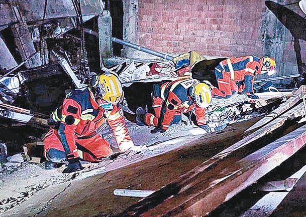 救援隊在倒塌的樓宇中搜索生還者。