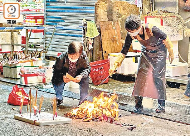 海鮮檔店員在門外點燃香燭及燃燒冥鏹拜祭。（陳嘉順攝）