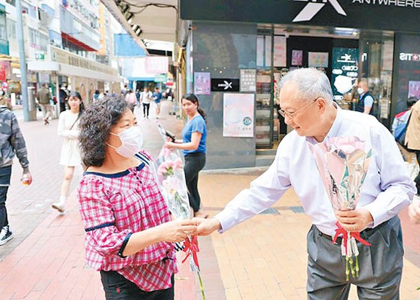 張宇人（右）喺銅鑼灣街頭向女士贈送鮮花。