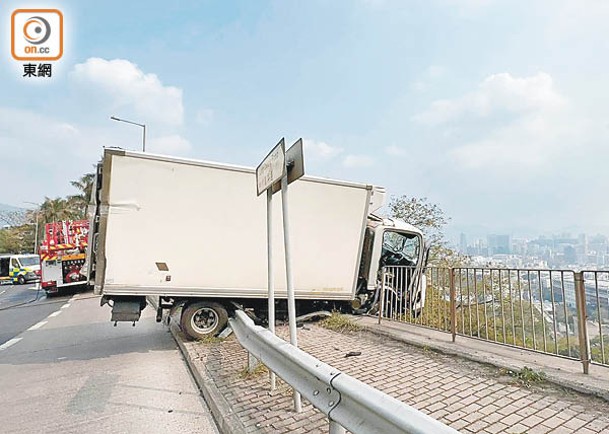 貨車後轆被防撞欄卡住。