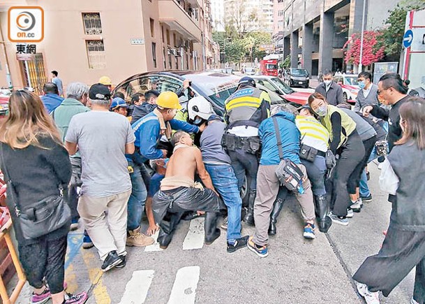 旺角：10多名熱心市民協助抬車救人。（張開裕攝）