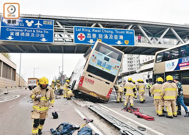 一輛載客雙層九巴在分岔路口撼欄後剷上石壆傾側。