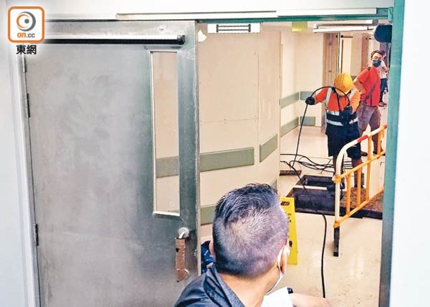 屯門醫院工作人員用儀器吸走積水。