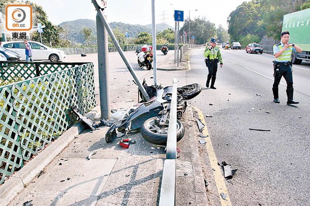 死者駕駛的電單車被撞上行人路，路牌亦被撞毀。