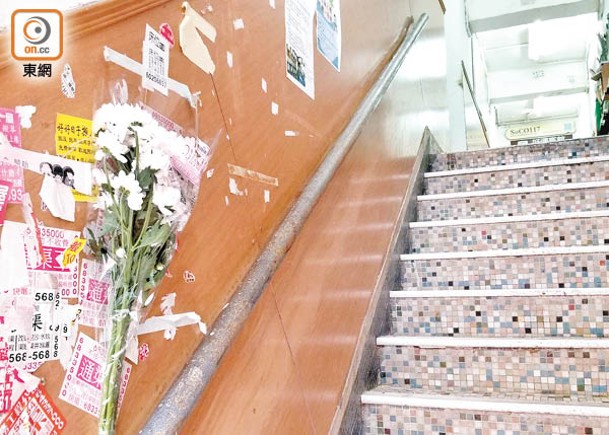 大廈樓梯旁放有致祭鮮花。