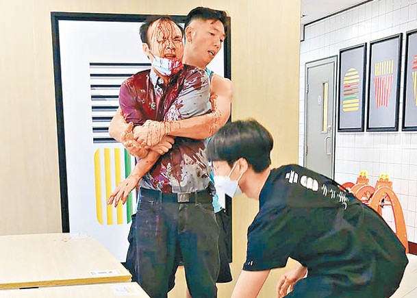 休班消防員緊抱傷者，疑為防止他亂動導致失血過多。