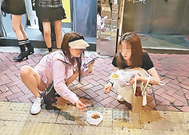 兩遊客踎街吃小食  網民：好地道