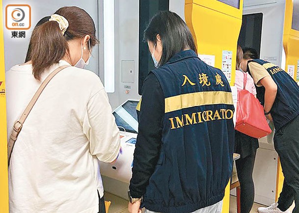入境處職員在場協助市民領證。
