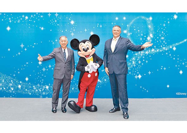 （左起）新世界發展執行董事薛南海、米奇老鼠，與香港迪士尼樂園度假區行政總裁莫偉庭。
