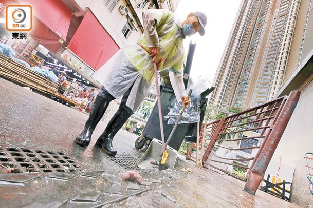 有清潔工於楊屋道街市外清理地面肉碎。