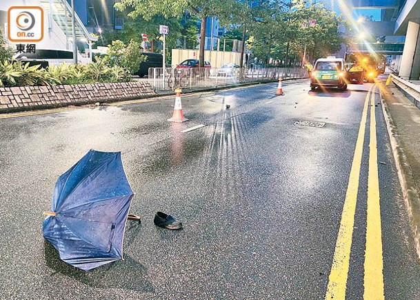 路中遺下一隻鞋及一把雨傘。（沈厚錚攝）