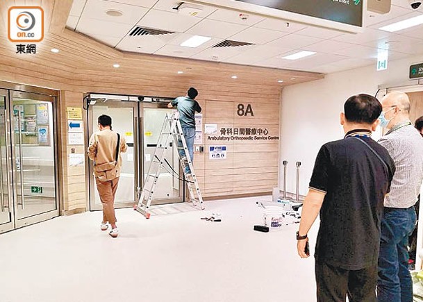 廣華醫院骨科日間醫療中心一對自動門有零件脫落，工程人員檢查維修。（陳嘉順攝）