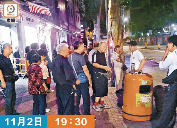 數名旅客用膳後在街道吸煙候車。