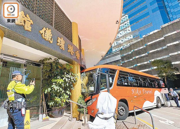 旅遊巴士失控猛撼香港殯儀館正門石柱。（吳鎮興攝）