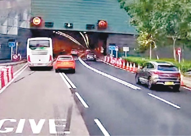 橙色私家車在隧道口越過雙白線。