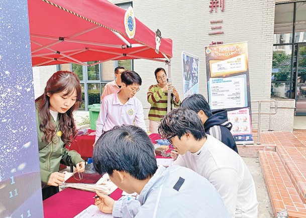 華僑大學學生在招募攤位即場報名投考懲教署。
