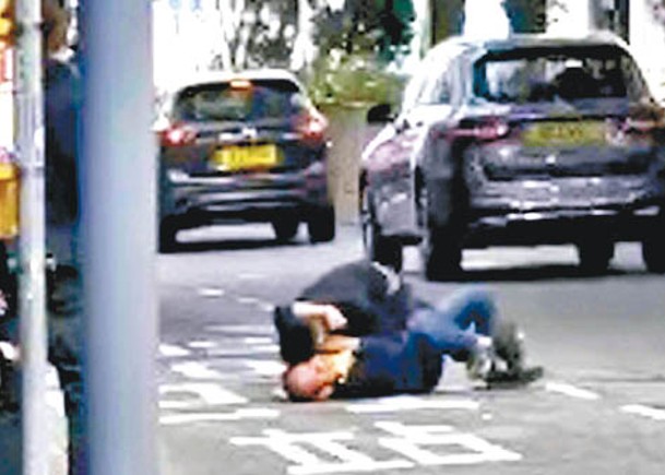 兩名男子在馬路中央倒地糾纏。