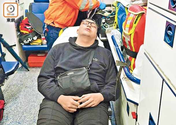 一名傷者躺在擔架床上等候送院。