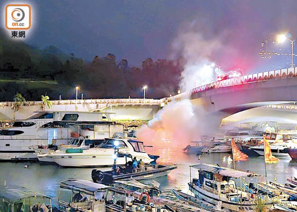 消防員在橋面向起火船隻射水撲救。（沈厚錚攝）