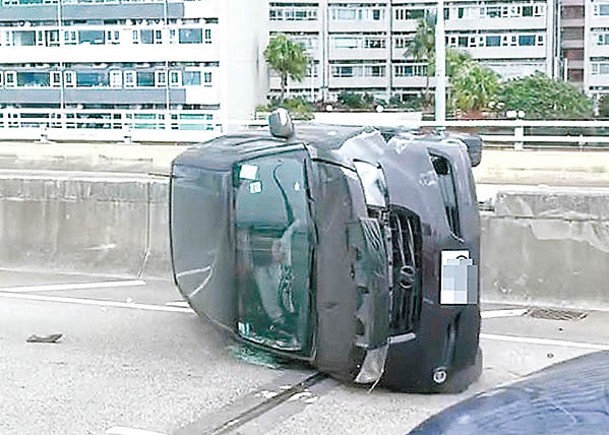 私家車在相撞後翻側，女司機被困。