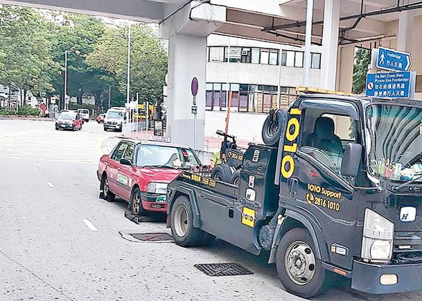 荃灣：阻塞道路的士被拖走。