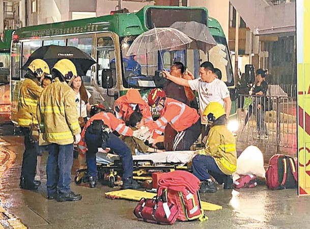 西灣河：不少熱心市民為捱車撞女童撐傘遮擋風雨。