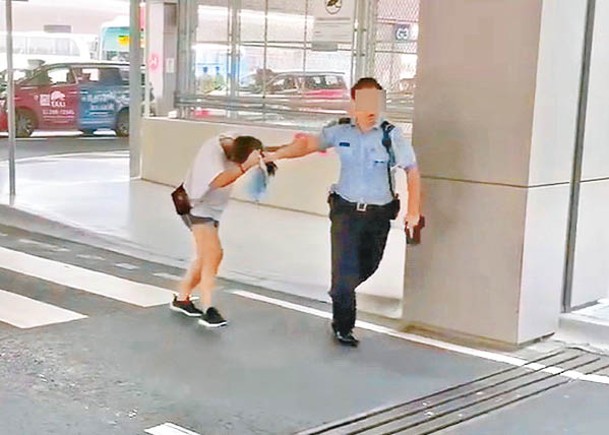 一名治安警員被攝得拉扯女子的馬尾辮。
